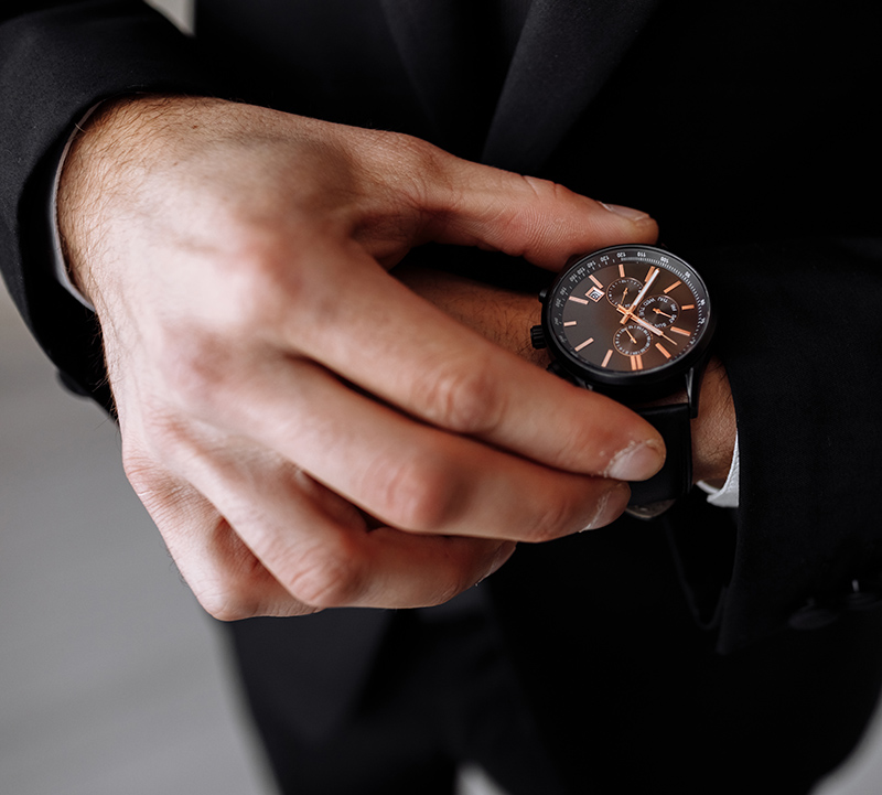 businessman looks at the watch on his wrist, looks at the time. High quality photo.